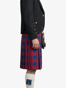 Person wearing a black jacket and red and blue plaid kilt on a white background