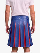 A person shown from the back wearing a blue leather pleated kilt with red pleated lining and silver-tone metal hardware, paired with a light pink t-shirt and white socks, against a plain light gray background.