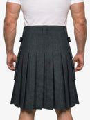 Person wearing a gray pleated kilt on a white background