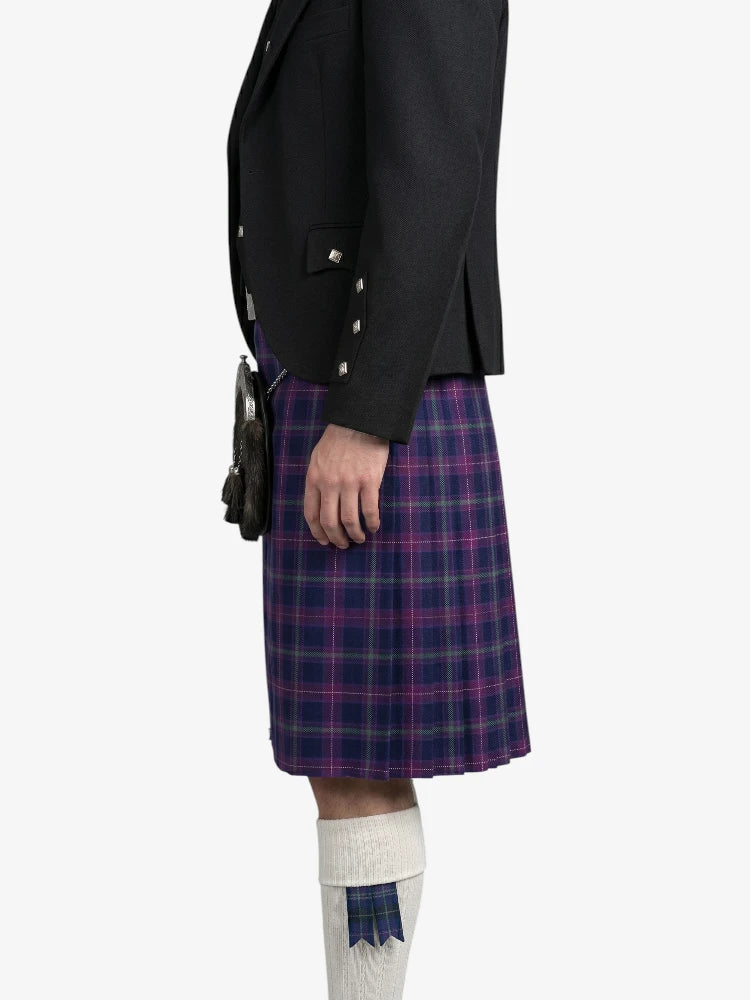Person wearing a black jacket and purple plaid kilt on a white background