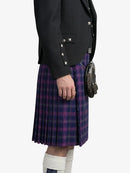 Person wearing a black jacket and purple plaid kilt on a white background