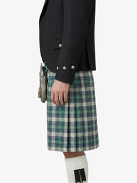 Person wearing a black jacket and plaid kilt on a white background