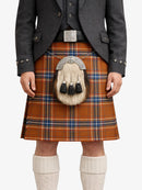 Person wearing a traditional Scottish kilt with a tartan pattern on a white background