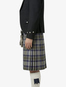 Person wearing a black jacket and plaid kilt on a white background
