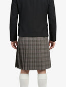 Person wearing a black jacket and plaid kilt on a white background