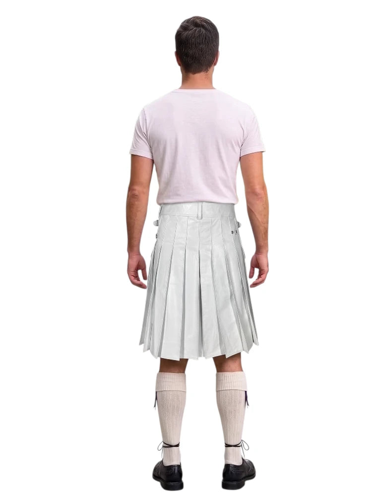 A man shown from the back wearing a white pleated kilt, a light pink t-shirt, beige knee-high socks, and black shoes, isolated on a white background.