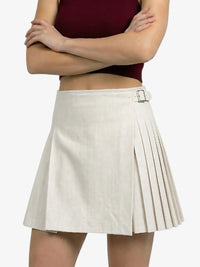 Person wearing a white pleated skirt with a belt on a white background