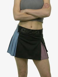Person wearing a black and blue pleated skirt on a white background