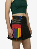 Person wearing a black skirt with rainbow pocket on a white background
