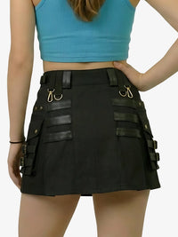 Person wearing a black skirt with leather straps and a blue top on a white background