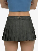 Person wearing a gray pleated skirt with a blue top on a white background