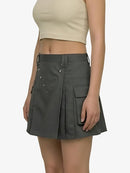 Person wearing a gray pleated skirt on a white background