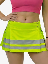 Person wearing a bright yellow skirt with reflective stripes on a plain background
