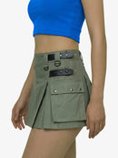 Green skirt with leather straps worn by a person on a white background
