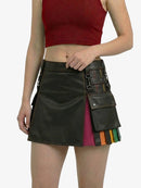 Person wearing a black leather skirt with colorful accents on a white background