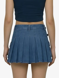 Person wearing a blue pleated skirt and navy top on a white background