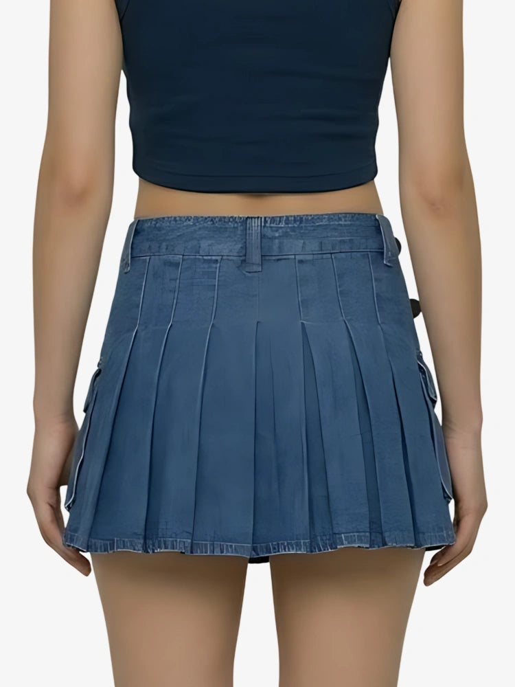 Person wearing a blue pleated skirt and navy top on a white background