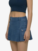 Person wearing a blue denim skirt on a plain background
